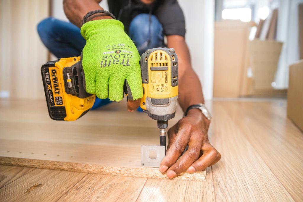 Personne utilisant une perceuse sur un morceau de bois