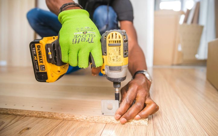 Personne utilisant une perceuse sur un morceau de bois